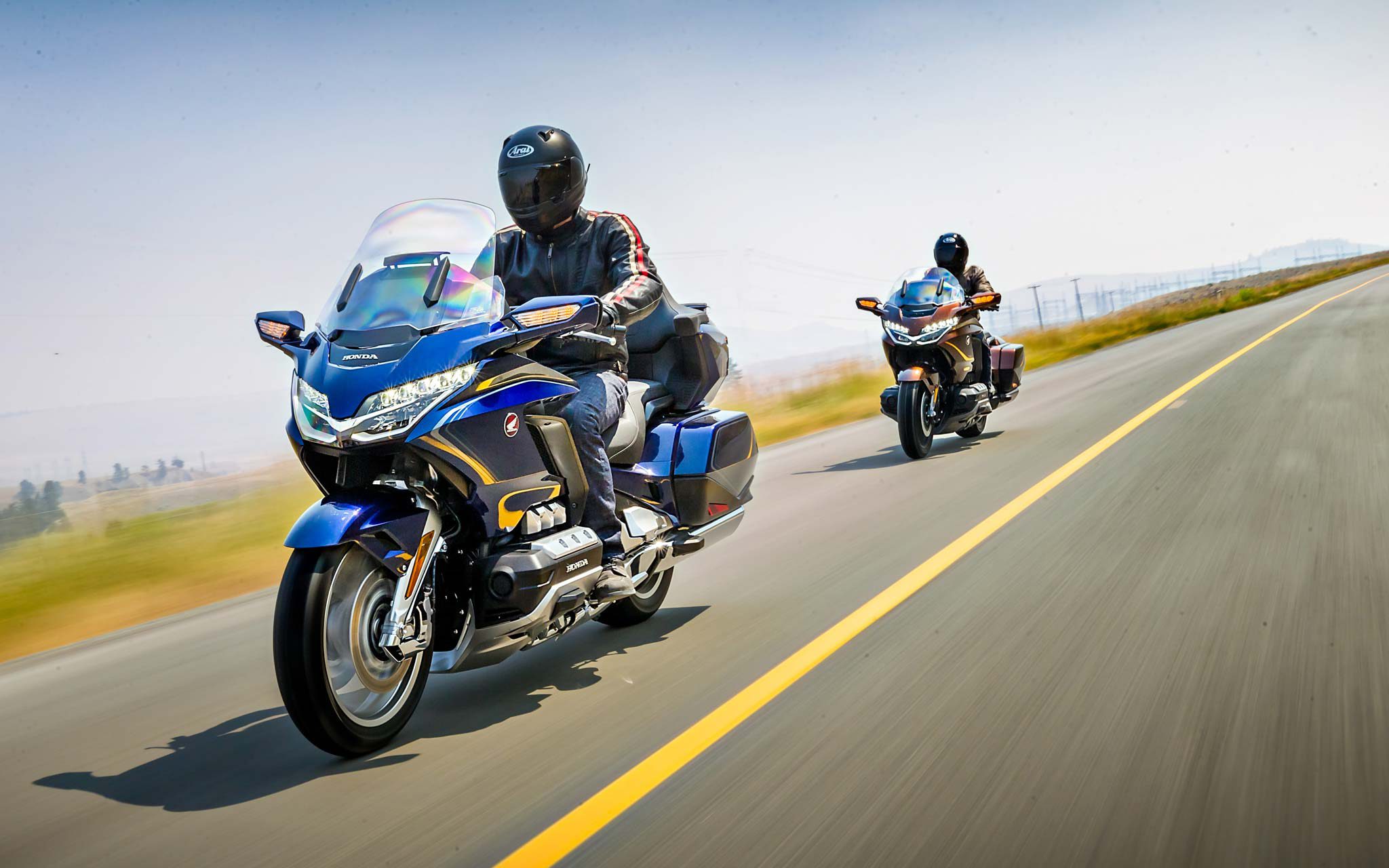 Two Honda Goldwing riders cruising down the highway