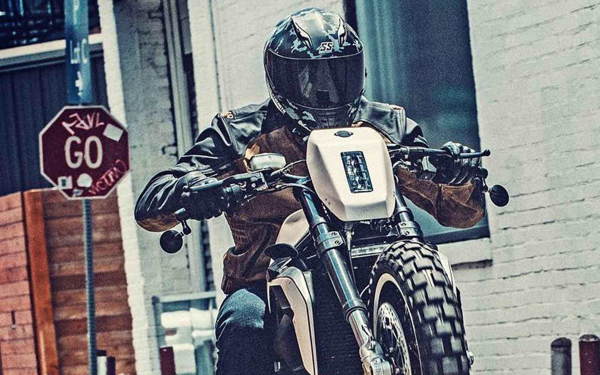 Motorcycle rider in Speed and Strength gear revving at stop sign