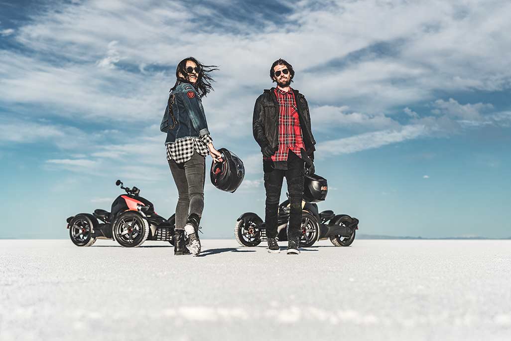 Two riders pose walking to and from Can Am Rykers in background