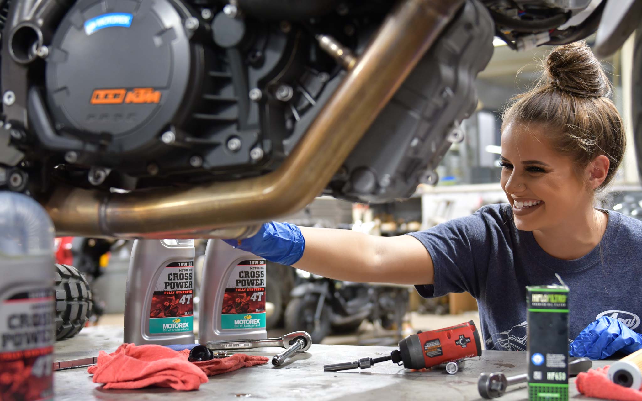 service tech happily servicing customer's motorcycle