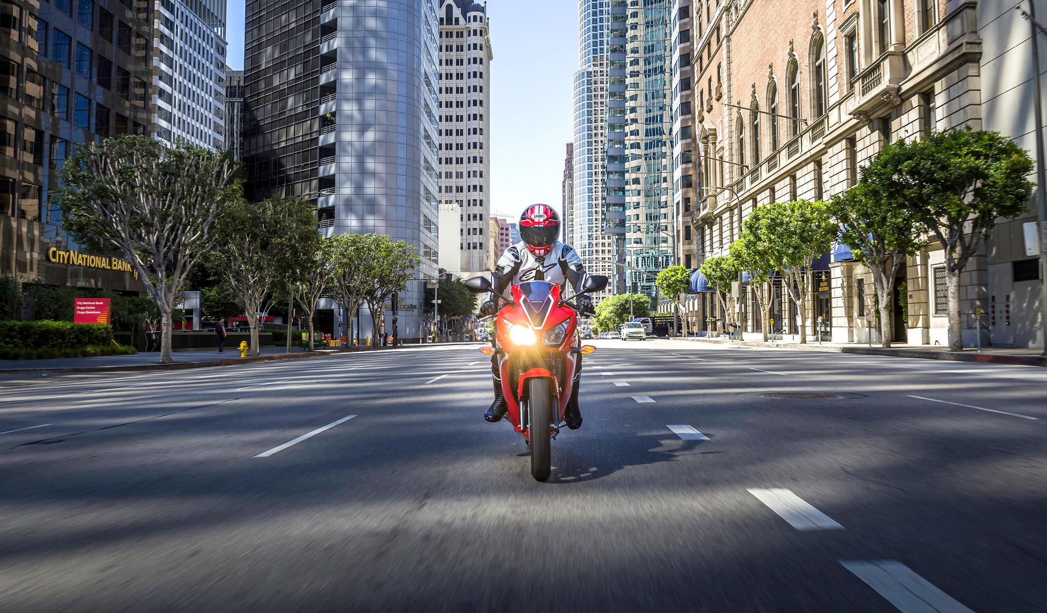 Motorcycle rider heading straight for camera on open city street