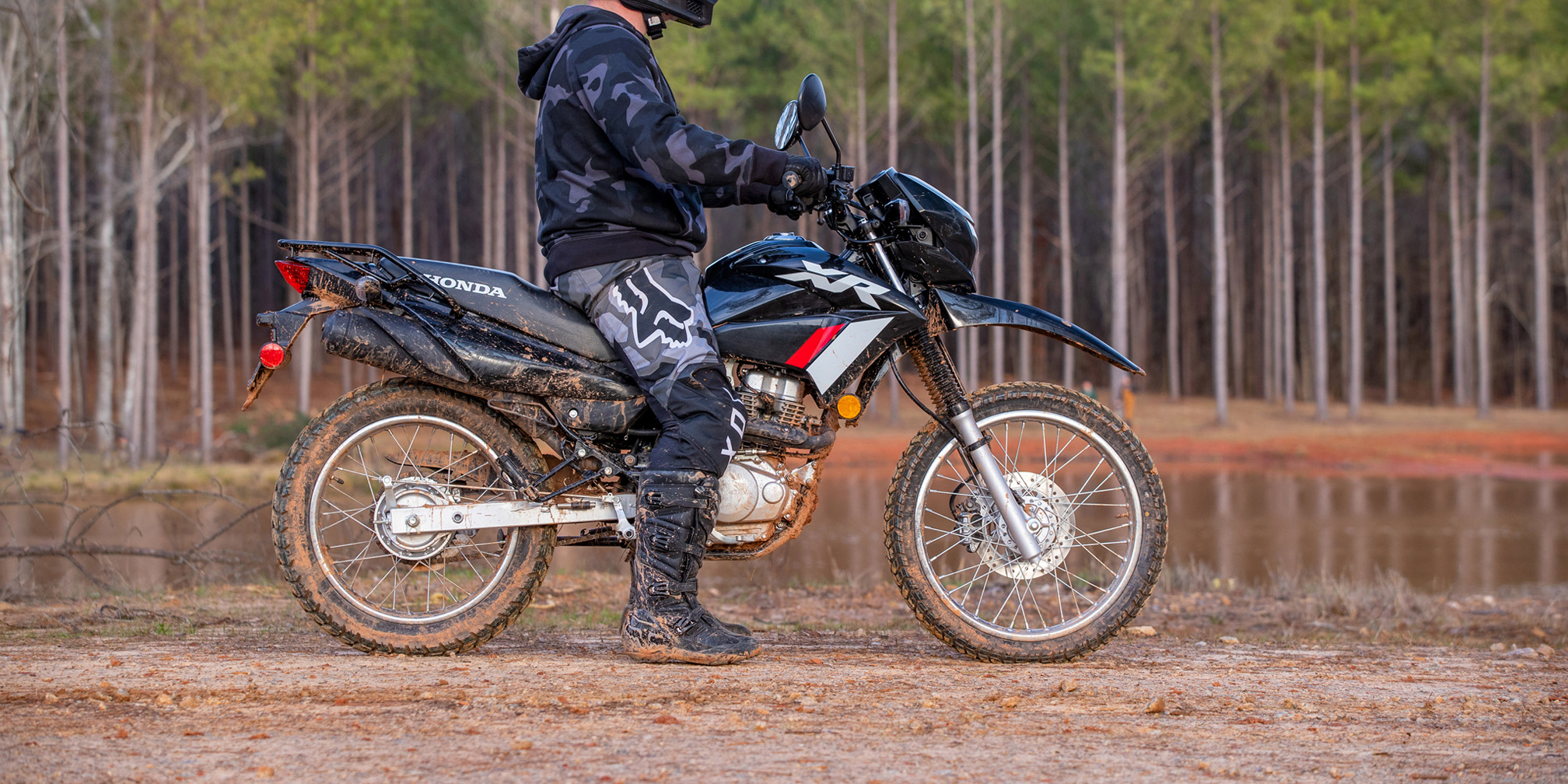 Lifestyle of dirt rider parked in front of pond